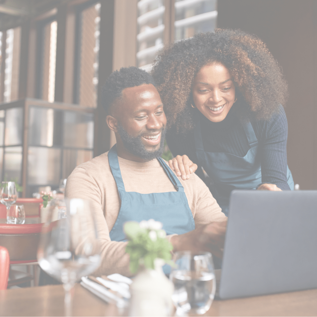 Young business partners (man and a woman) review business information on a laptop.
